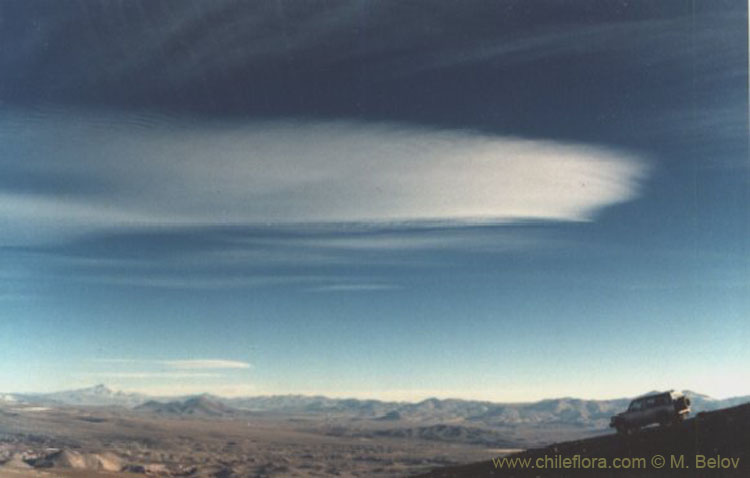 An image of a jeep on a mountain slope with blue sky and some clouds, near Salar de Pedernales, Chile.