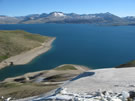 View of Laguna Maule, with some snow-covered slopes in the foreground.