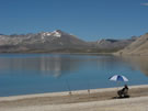 A lone recreational fisherman is sitting and waiting for fish to bite at Laguna Maule.