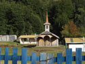 Image of a traditional wooden church behind locked wooden gate near Co�aripe, Chile.
