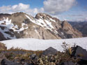 Summer Snow:  A view of a steep, rocky mountain in the background with a snowfield, Radal Siete Tasas National Park.