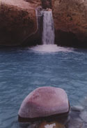 Peace:  An image of a small waterfall with a stone in the foreground, in the Yerba Loca valley, Chile.