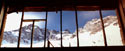 The Window to Beyond:  An image of a wooden window frame through which a glacier of El Morado can be seen, taken from the road to Embalse de Yeso in the military barracks.